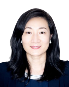 Portrait of a smiling woman with long black hair and pearl earrings.