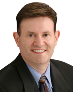 Professional headshot of a man in a suit smiling.